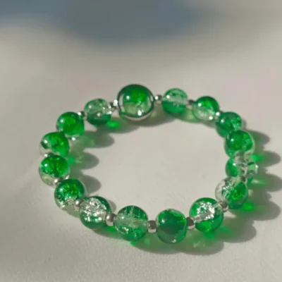 Close-up of handmade green crackle glass beaded bracelet by Stay Decorative